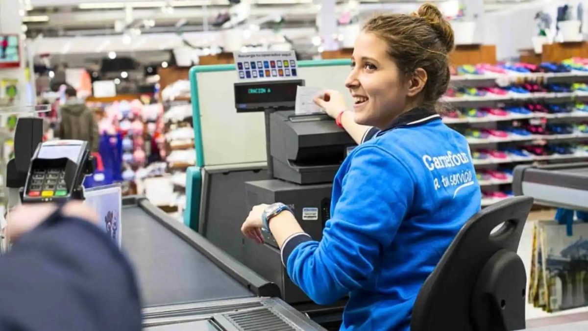Una trabajadora de Carrefour cobrando en caja.