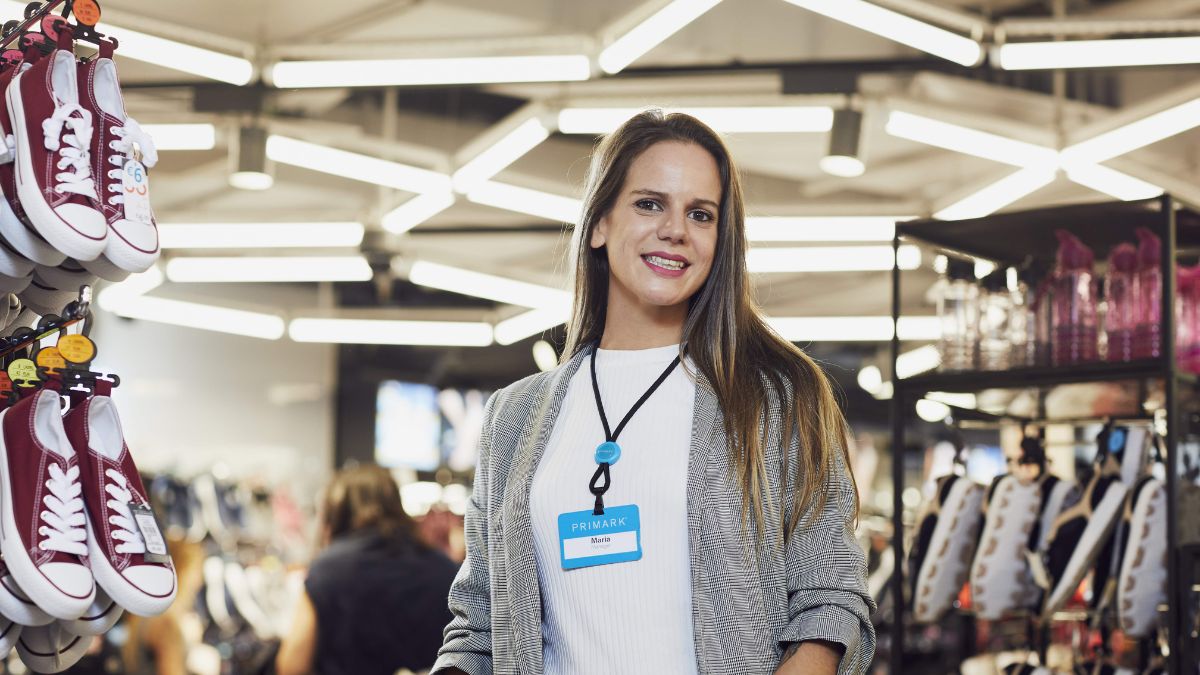 Una trabajadora de Primark sonriendo en la tienda.