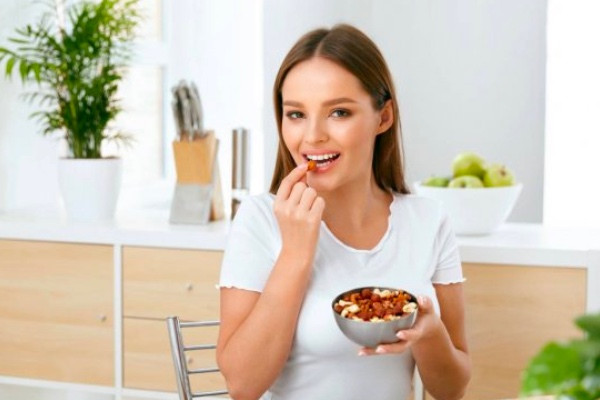mujer comiendo anacardos