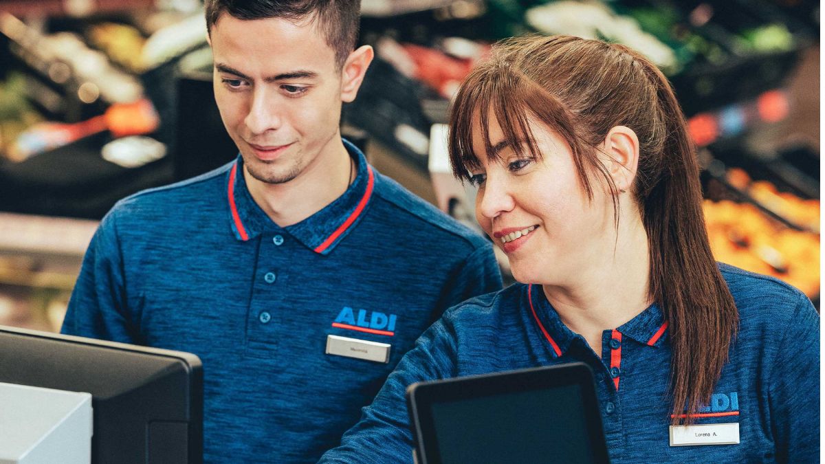 Dos trabajadores de Aldi frente a un ordenador.