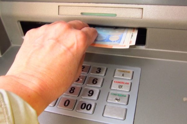 Un pensionista sacando dinero del cajero