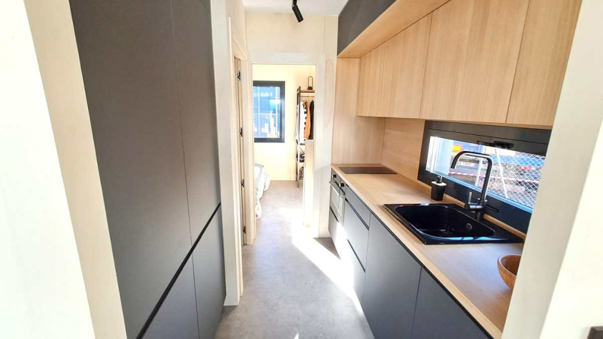 Cada vez son más personas las que optan por una casa prefabricada y es que los modelos disponibles en el mercado cada vez son más versátiles y se adaptan mejor a las necesidades del día a día. Es habitual encontrar viviendas de madera fabricadas en países nórdicos, pero lo cierto es que también las hay que se fabrican en España y que se pueden tener listas para entrar a vivir en menos de 45 días.   Se trata de la tiny house KYABIN de American Building System, una empresa de Guadalajara con 30 de experiencia en la en construcción industrializada de viviendas, que ha desarrollado este nuevo concepto de casa modular, que tardan en construir un máximo de 45 días, y cuya instalación en el terreno deseado se hace en tan solo un día.   Según explica la marca, Kyabin significa cabaña en japonés, y es en esto en lo que han inspirado su diseño, para construir una vivienda prefabricada de un solo módulo de 36 metros cuadrados con todas las comodidades y fabricado con diferentes maderas naturales.  Cómo es la casa prefabricada con aire oriental   Desde el exterior, la casa prefabricada es un ejemplo de elegancia, con un diseño de líneas sencillas que se adaptan a cualquier espacio con un porche con techo voladizo que se convertirá en uno de esos espacios que invitan a relajarse y pasar tiempo disfrutando del aire libre.   Así como su exterior transmite la elegancia en su diseño, el interior lo hace al la máxima comodidad y confort, con una distribución pensada para aprovechar al máximo el espacio, en un claro ejemplo de que cada centímetro cuenta.   Los acabados interiores son modernas y acogedoras, con puertas lacadas en blanco, cocina amueblada y equipada con acabado en antracita mate, encima de acabado roble, luces LED e iluminación en el interior de los cajones y electrodomésticos como placa vitrocerámica, campana extractora y termo eléctrico.    El resto de la vivienda dispone de las instalaciones de electricidad e iluminación exterior además de la fontanería e instalación de climatización mediante un sistema de expansión directa oculto en el falso techo.   La sostenibilidad es otro punto a su favor, y es que reducirá en un 90% la huella de carbono frente a la de una vivienda tradicional de similares características, algo de vital importancia la aprobación de la nueva normativa europea en cuanto a eficiencia energética, con la que gran parte de las viviendas en España deberán ser reformadas antes de 2030.