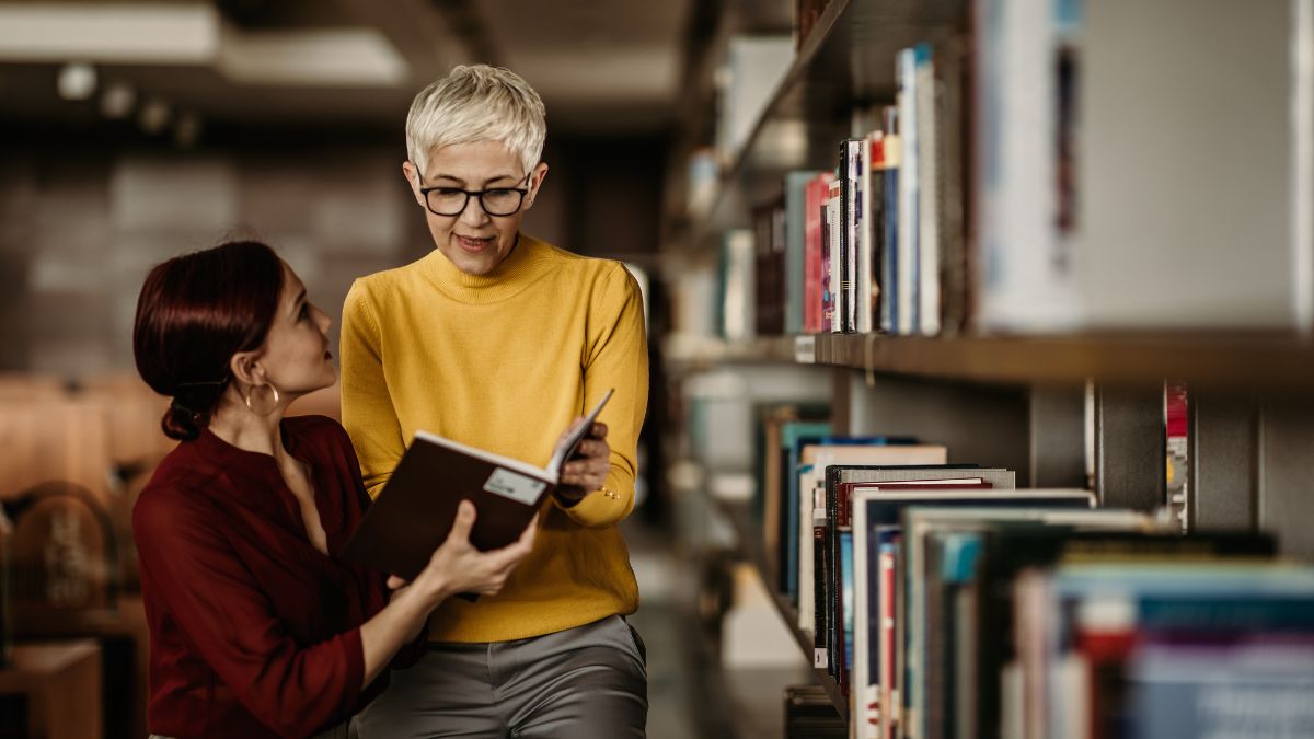 Una mujer atiende a las explicaciones de la bibliotecaria