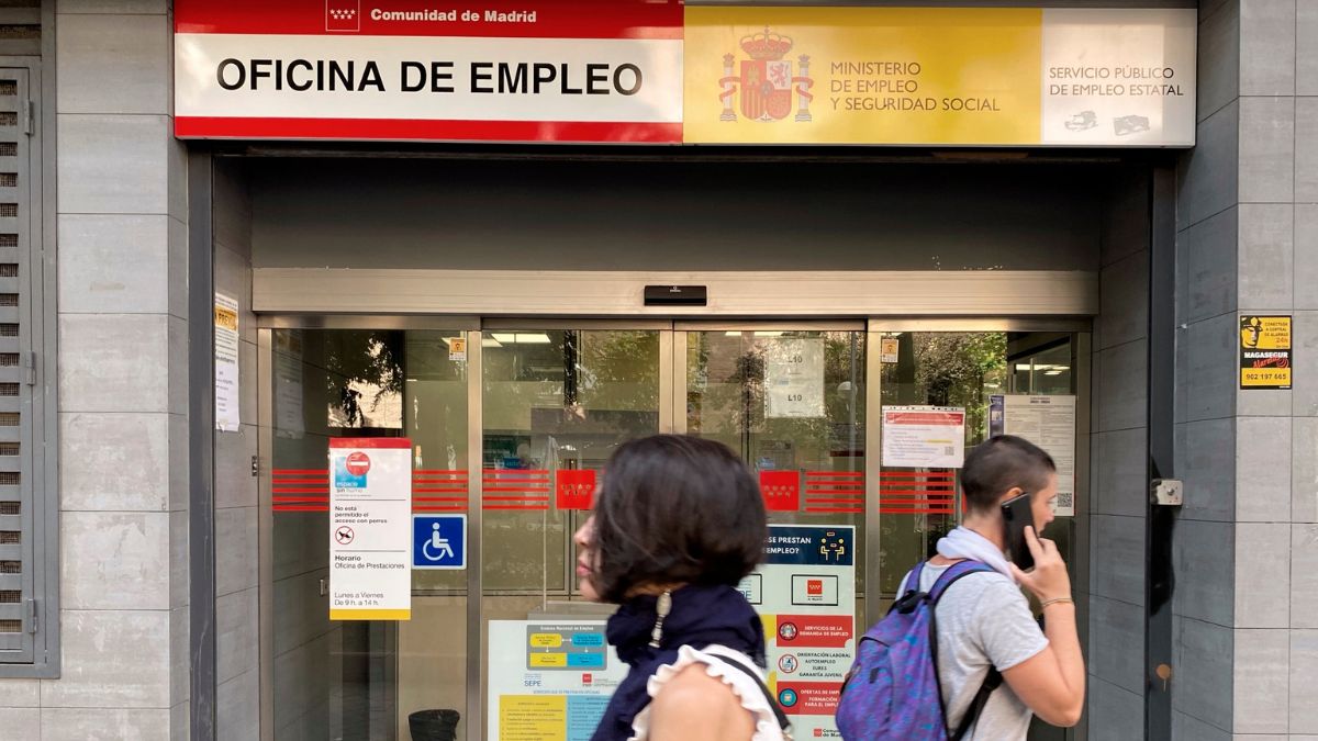 Dos personas pasean delante de una oficina de empleo y del SEPE